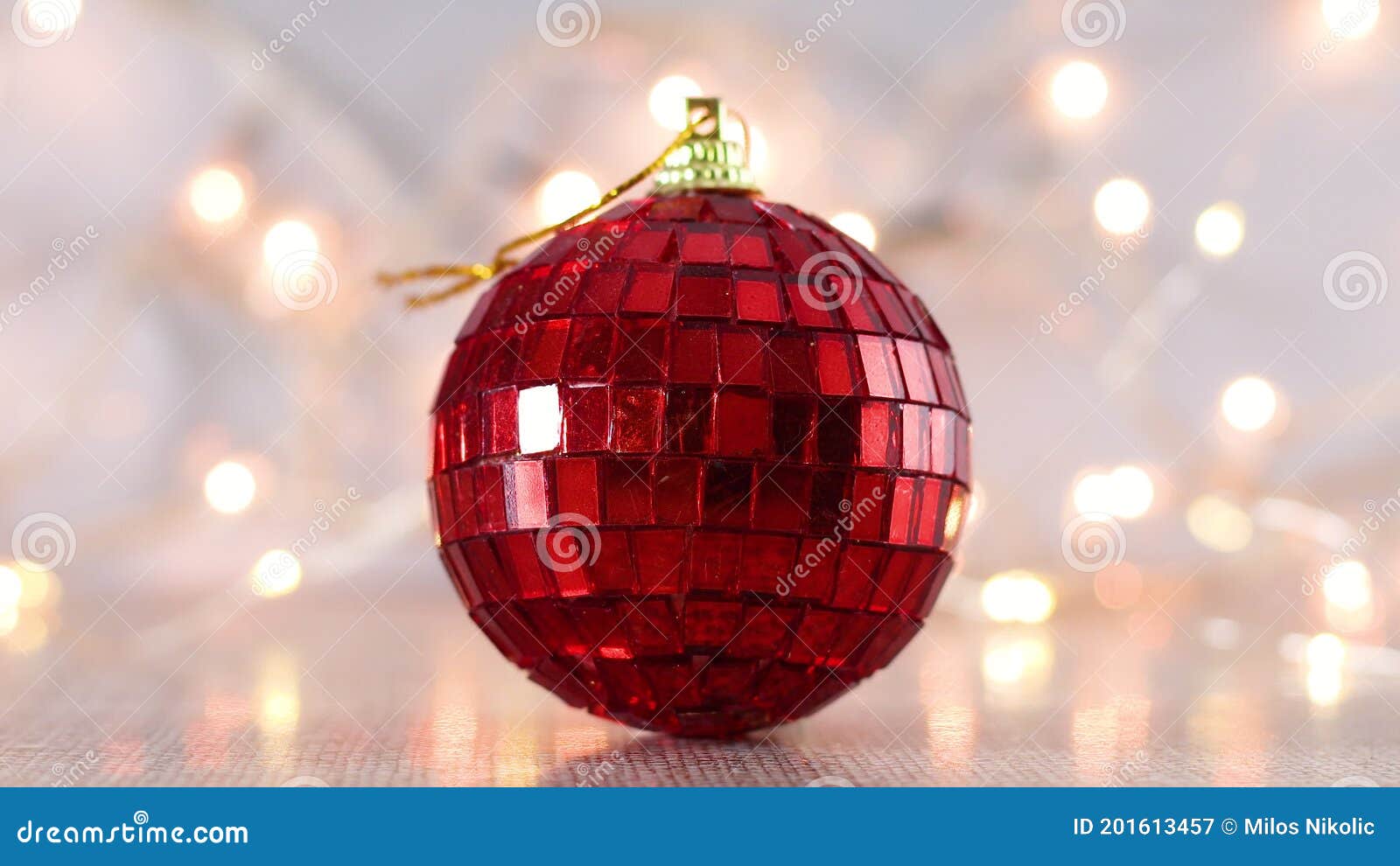 Christmas Red Disco Ball Ornament with Blinking Lights Behind Stock