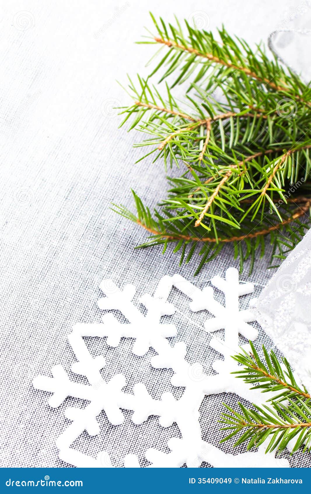 Christmas Tree Branch and White Christmas Ornaments on Soft Grey Stock