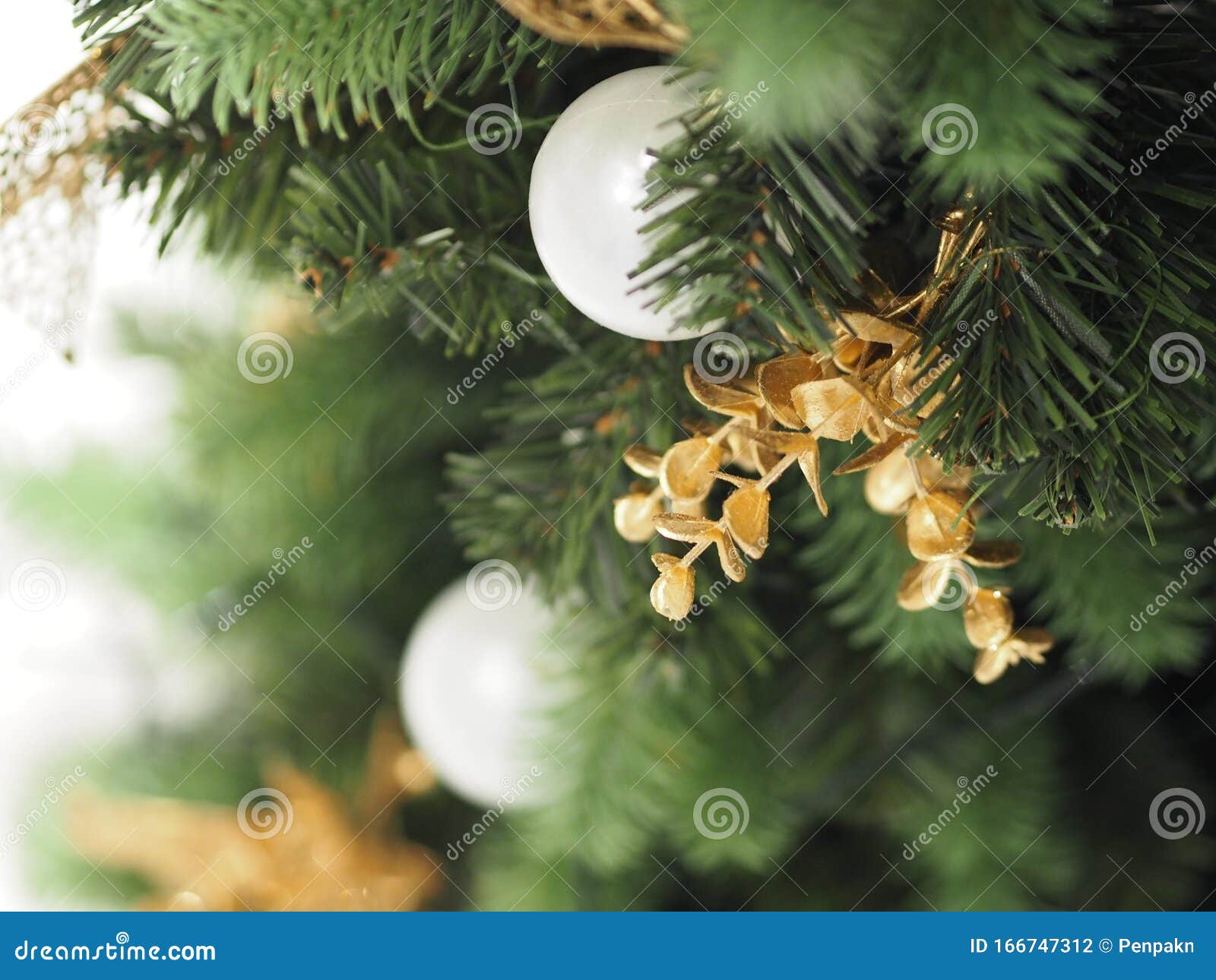 Christmas Tree Decorations Have White Ball, Gold Leaves on Blurred of