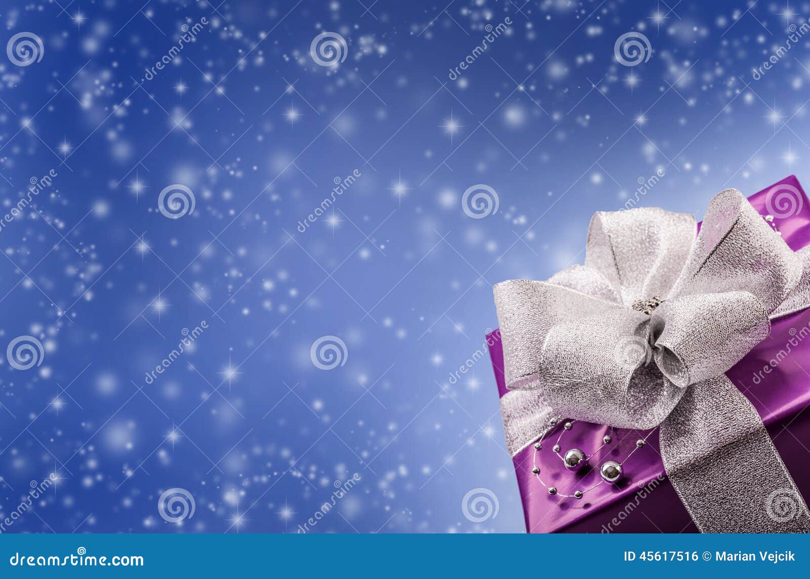 Christmas or Valentine s purple gift with silver ribbon abstract blue background.Christmas time