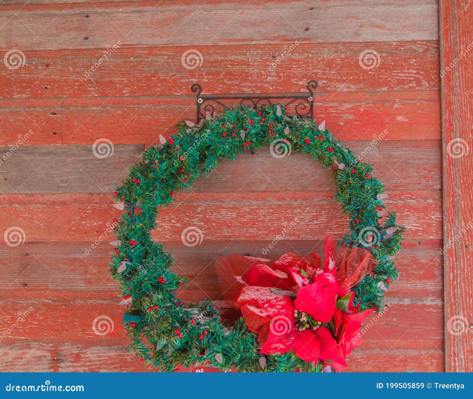 christmas wreath hanging on a rustic red door