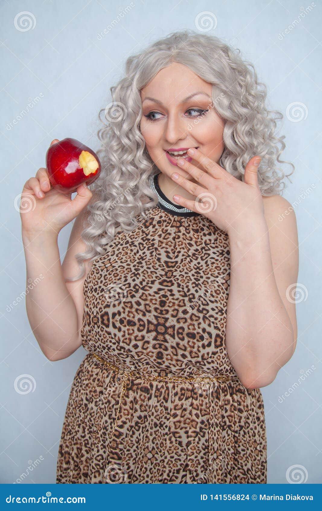 Chubby Blonde Girl Wearing Summer Dress And Posing With Big Red Apple On White Background Alone