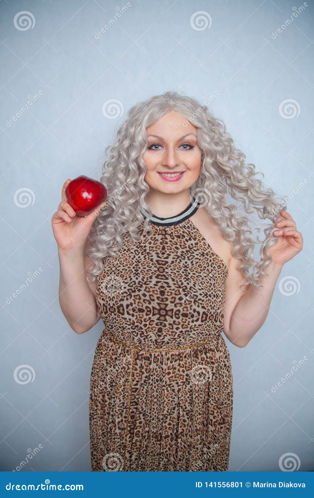 Chubby Blonde Girl Wearing Summer Dress And Posing With Big Red Apple On White Background Alone