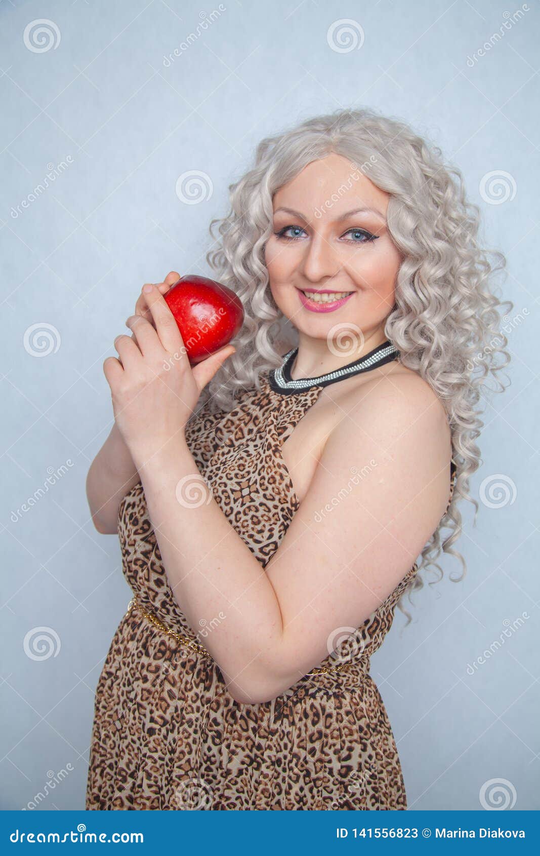 Chubby Blonde Girl Wearing Summer Dress And Posing With Big Red Apple On White Background Alone