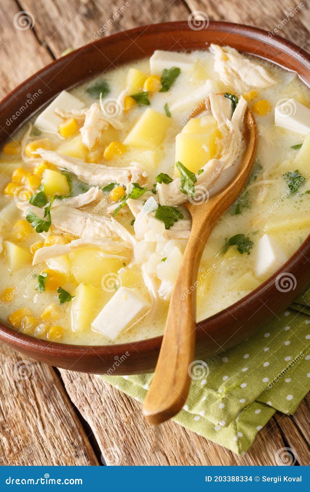 chupe andino is a traditional soup made from shredded chicken, cheese, vegetables and cream closeup in the plate. vertical