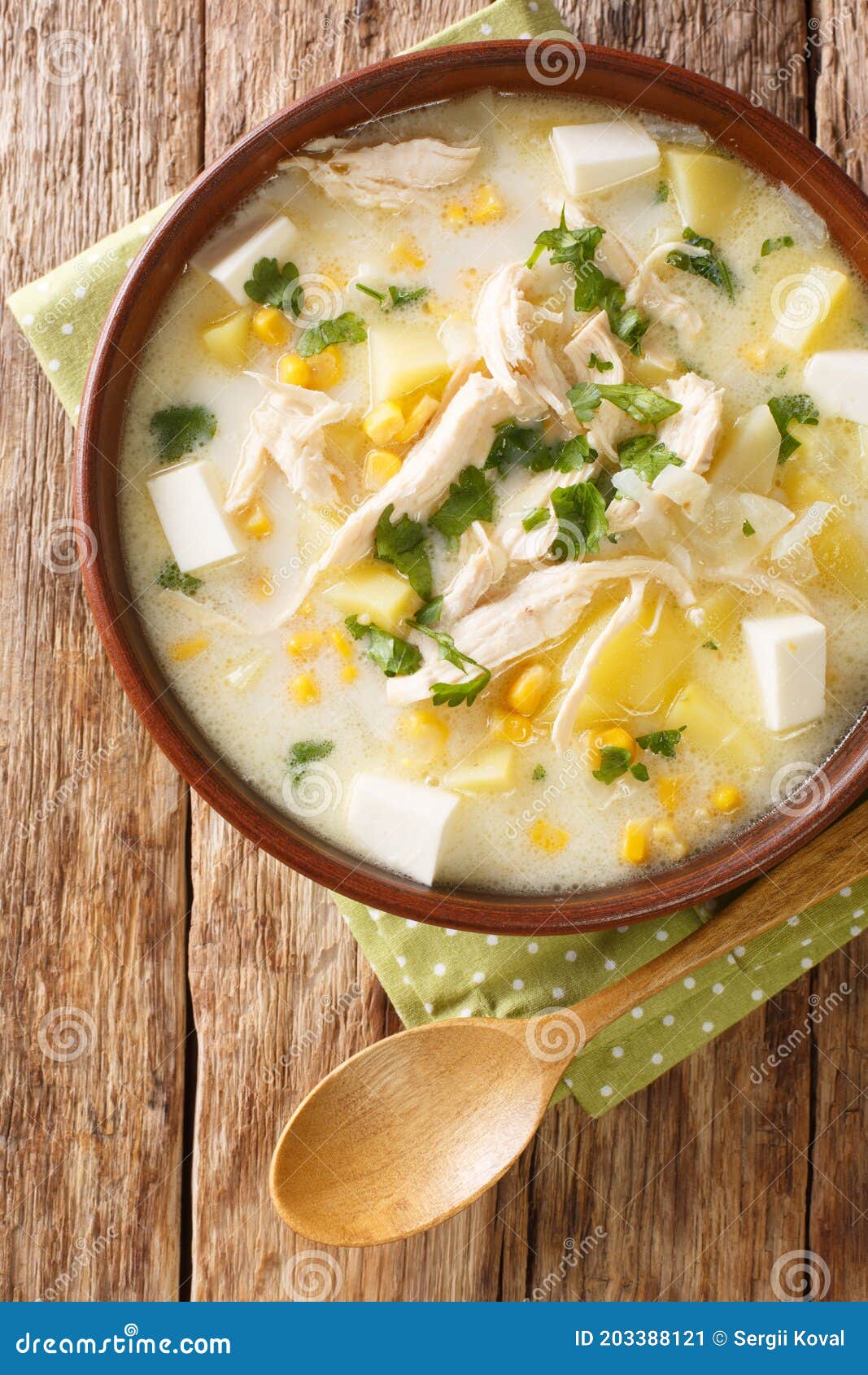 chupe andino is a traditional soup made from shredded chicken, cheese, vegetables and cream closeup in the plate. vertical top