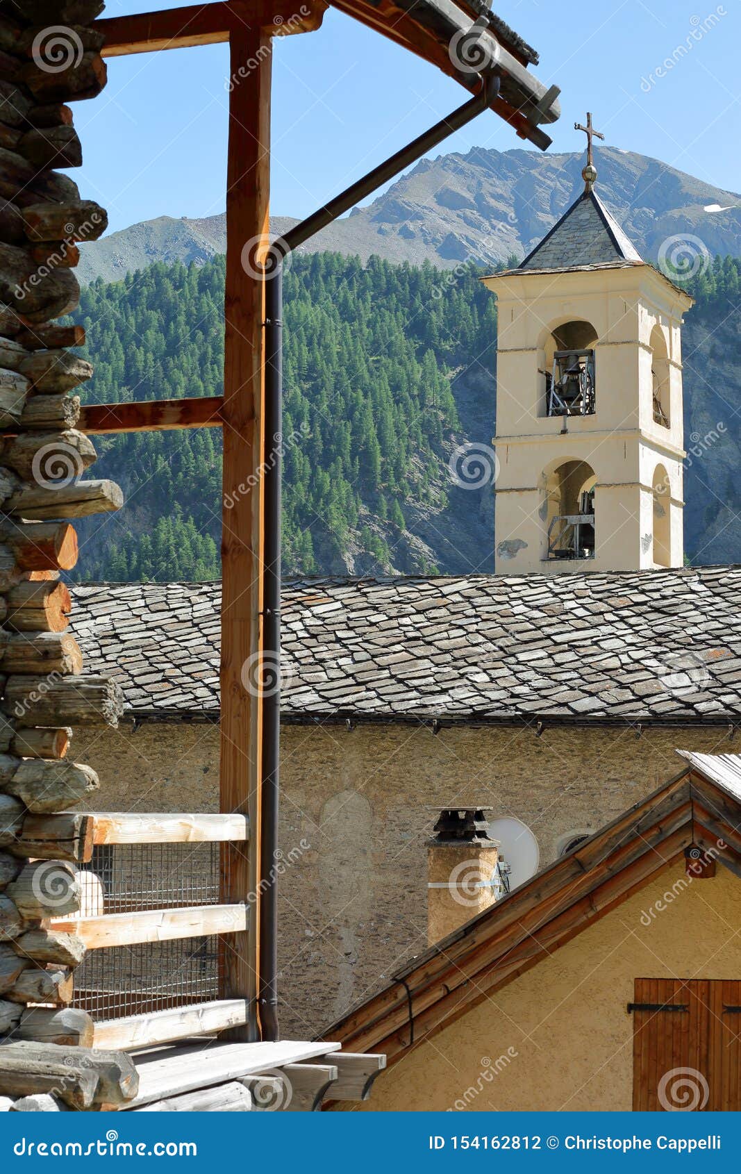 the church of saint veran with a traditional wooden house in the foreground and mountains in the background