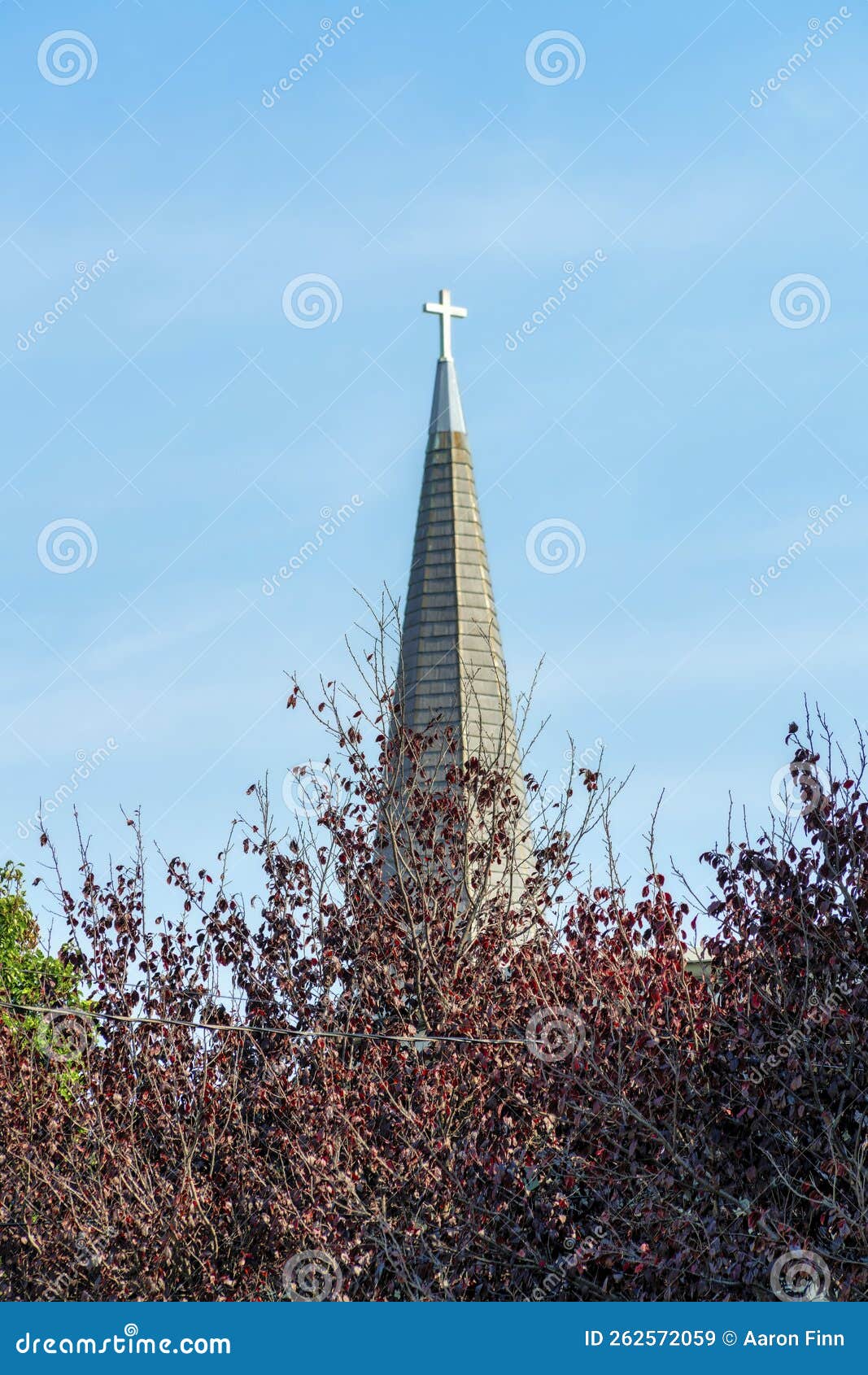 Church Steeple with Cross Atop the Pinnacle with Blue and White Lightly