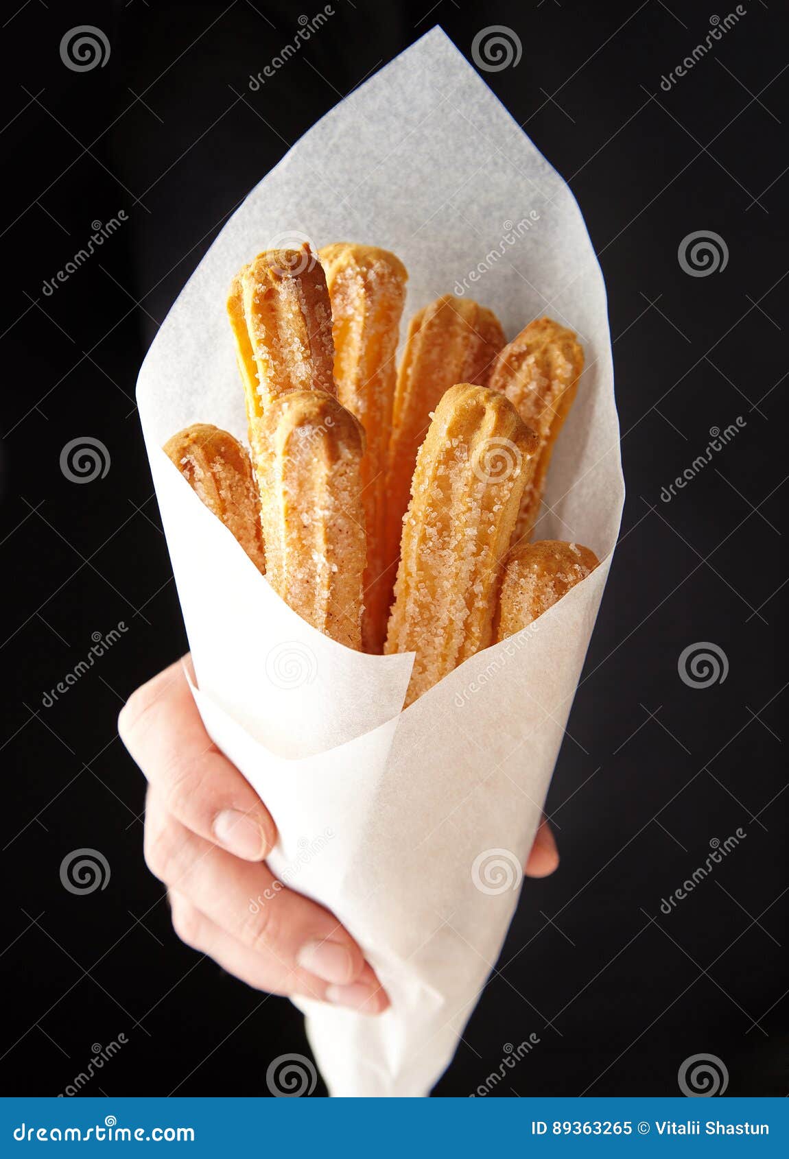 churros traditional spain or mexican street fast food baked sweet dough snack in hand