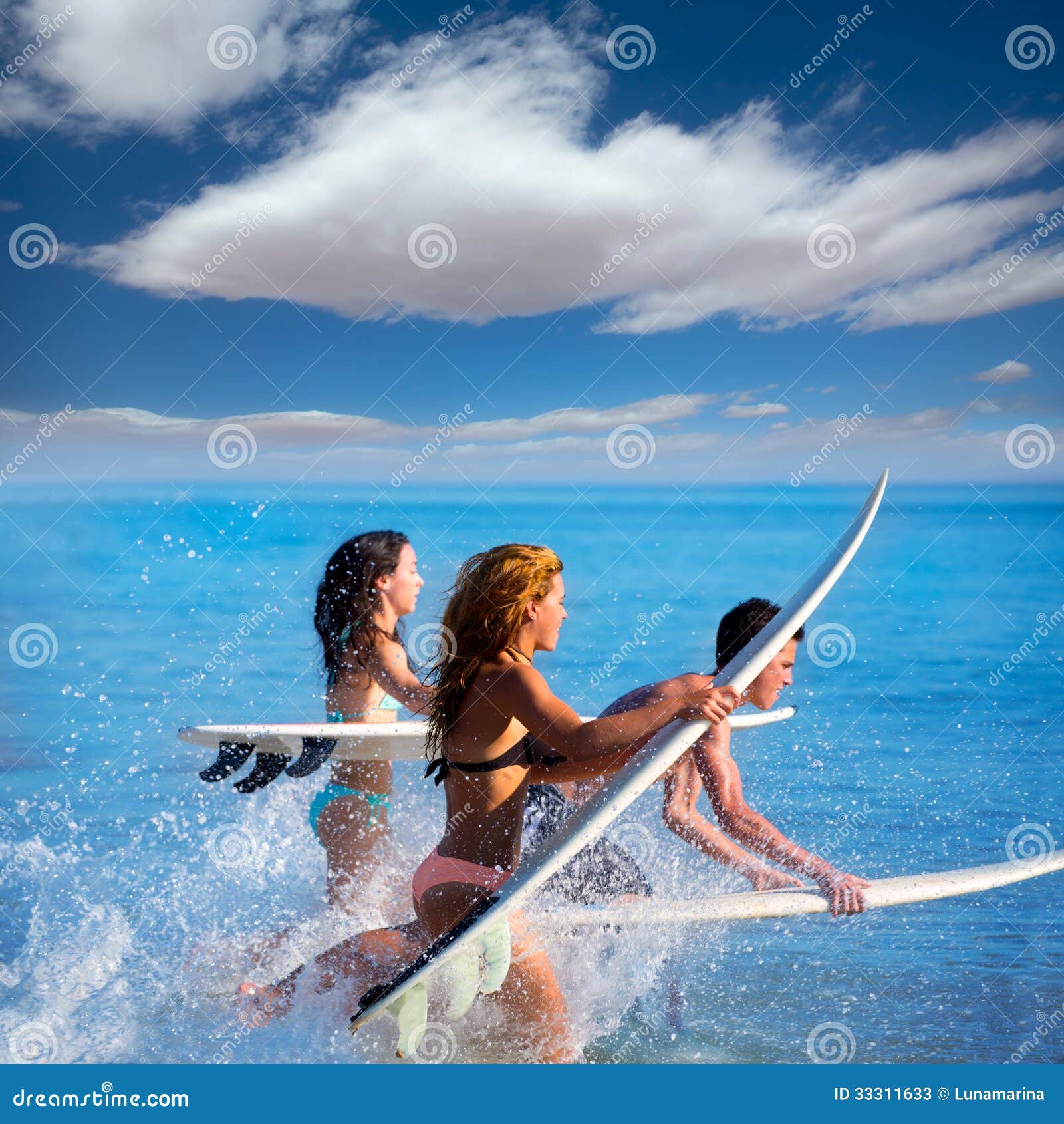 Chłopiec i dziewczyna nastoletni surfingowowie biega skakać na surfboards przy plażą