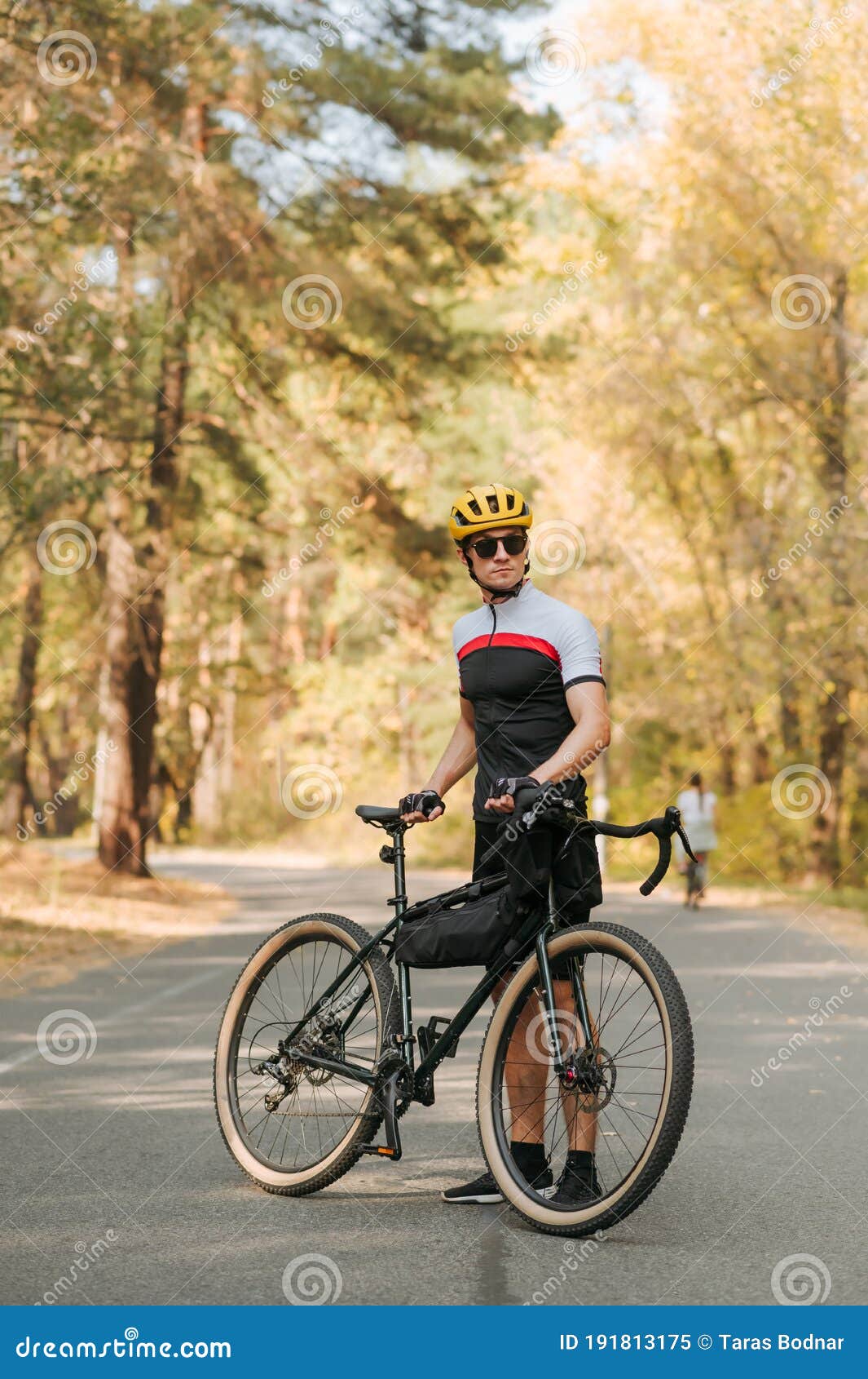 Ciclista En Un Equipo Deportivo Posa Para Una Cámara En La Carretera En Un  Bosque De Otoño Con Un Motociclista Y Mira Hacia Otro L Imagen de archivo -  Imagen de sunglasses