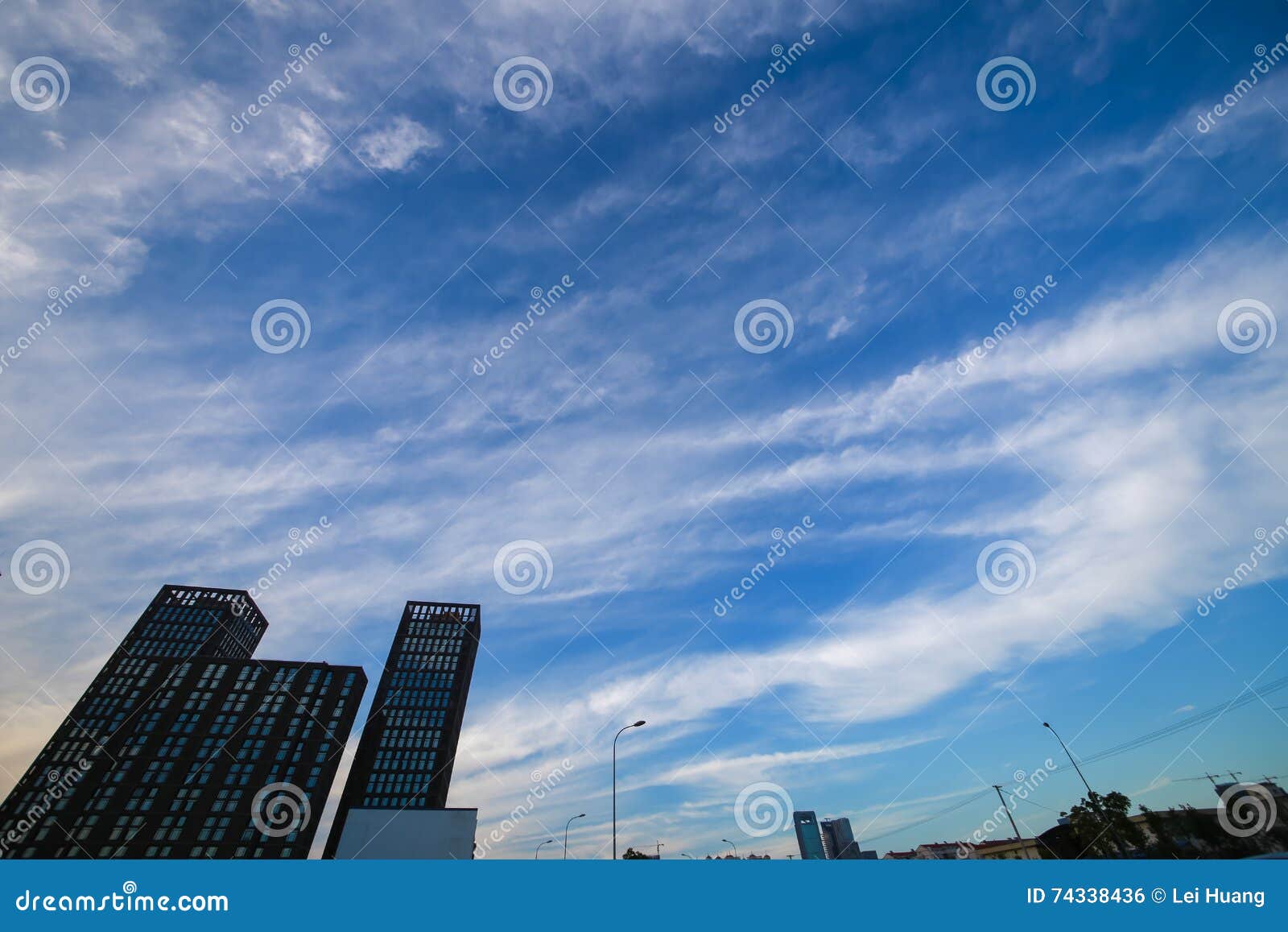 Pomeriggio soleggiato, il bianco del cielo blu si rannuvola la città Le immagini sotto sono alcune costruzioni ed alcune lampade di via