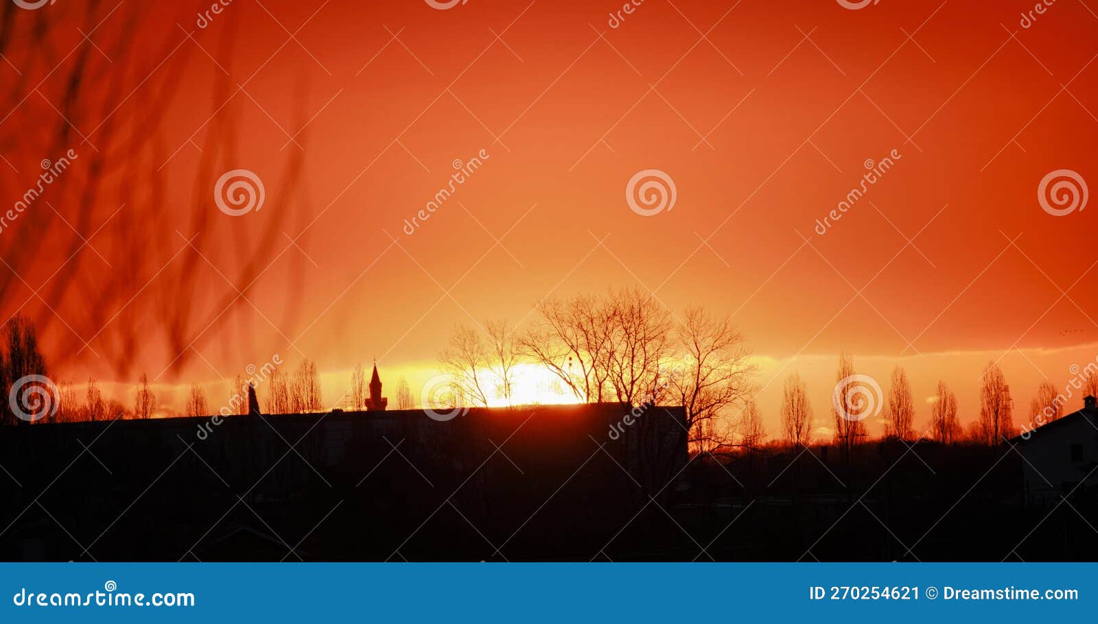 cielo arancione durante l'alba in un 'atmosfera suggestiva con legno e edificio in controluce