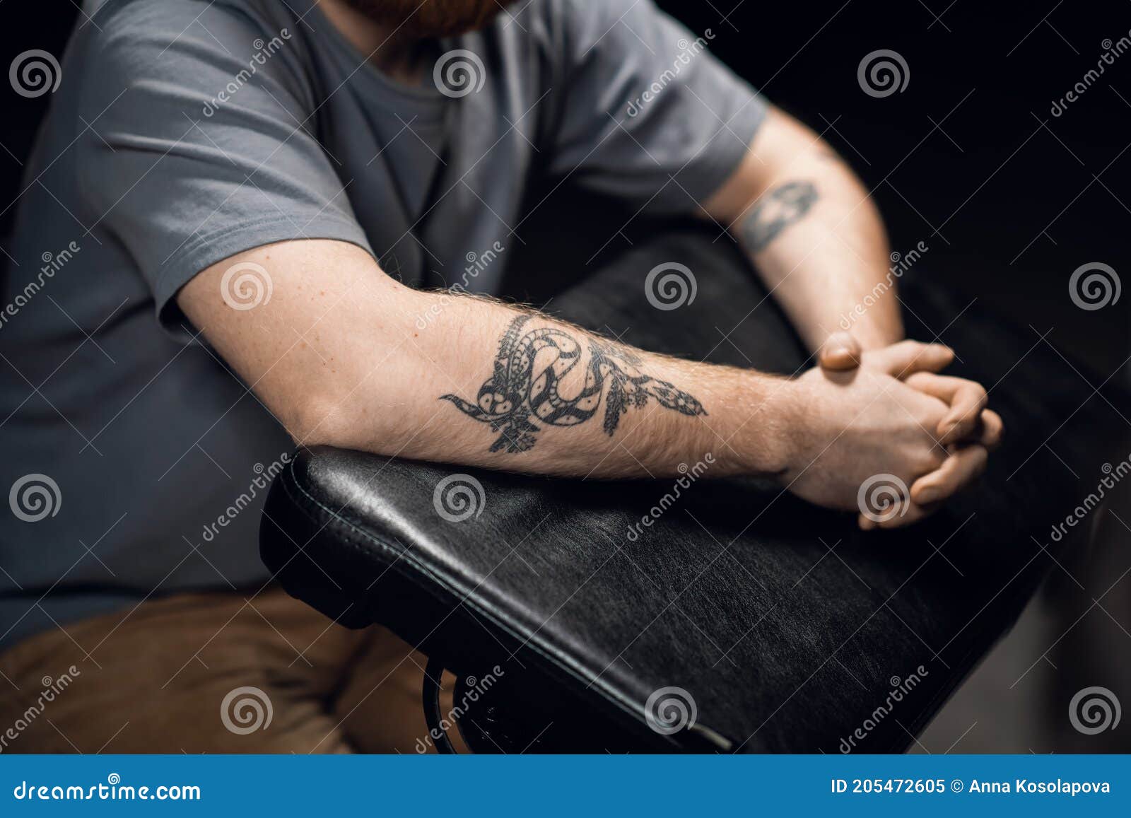Cierre De Las Manos De Un Hombre Con Un Tatuaje De Serpiente Sobre Una Mesa  De Tatuajes De Cuero En Una Sala De Tatuajes. Imagen de archivo - Imagen de  sala, adulto: