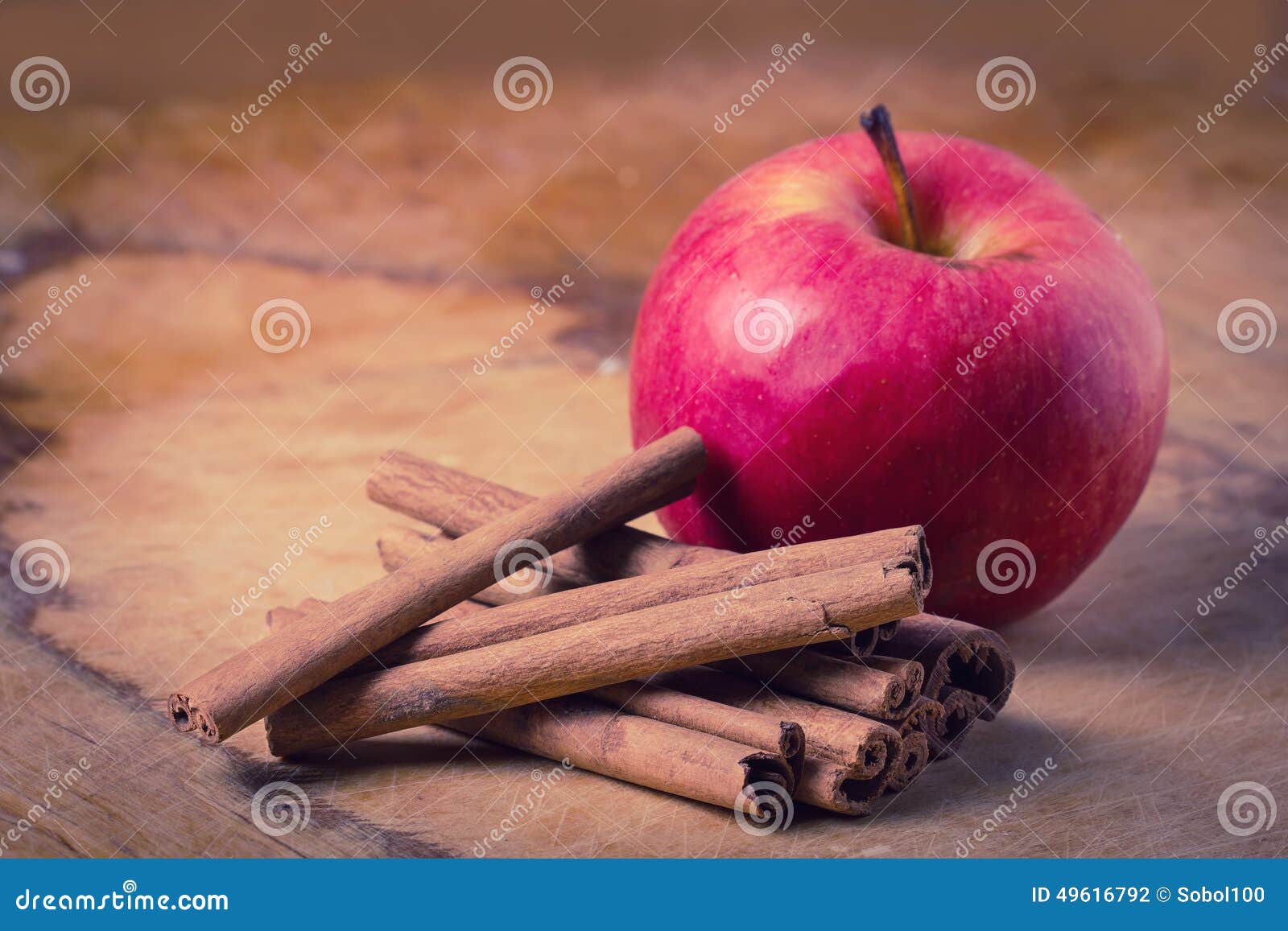 cinnamon and apple on wooden background.