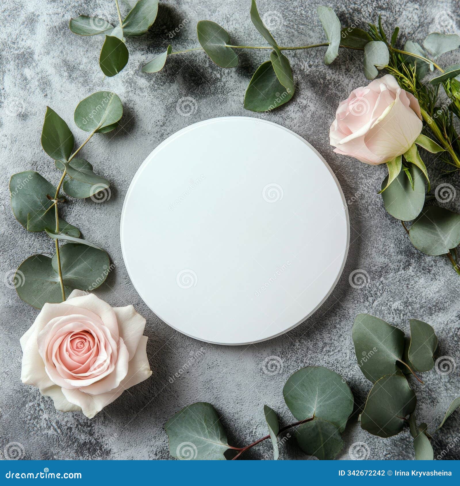 circular blank canvas surrounded by pink roses and greenery on a textured gray surface