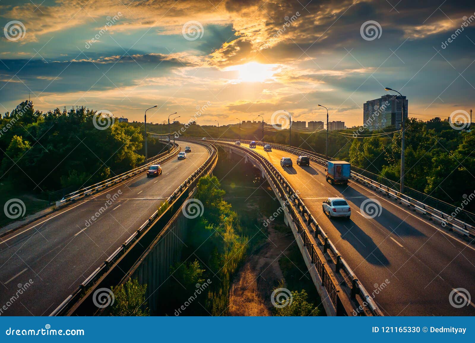 city traffic on asphalt road or highway route at sunset time, lot of cars drive with fast speed, urban transportation cityscape