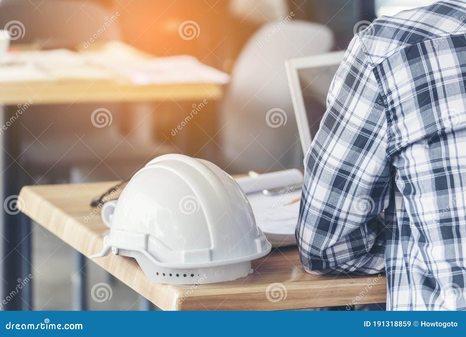 civil construction engineer working with laptop at desk office with white yellow safety hard hat at office on construction site.