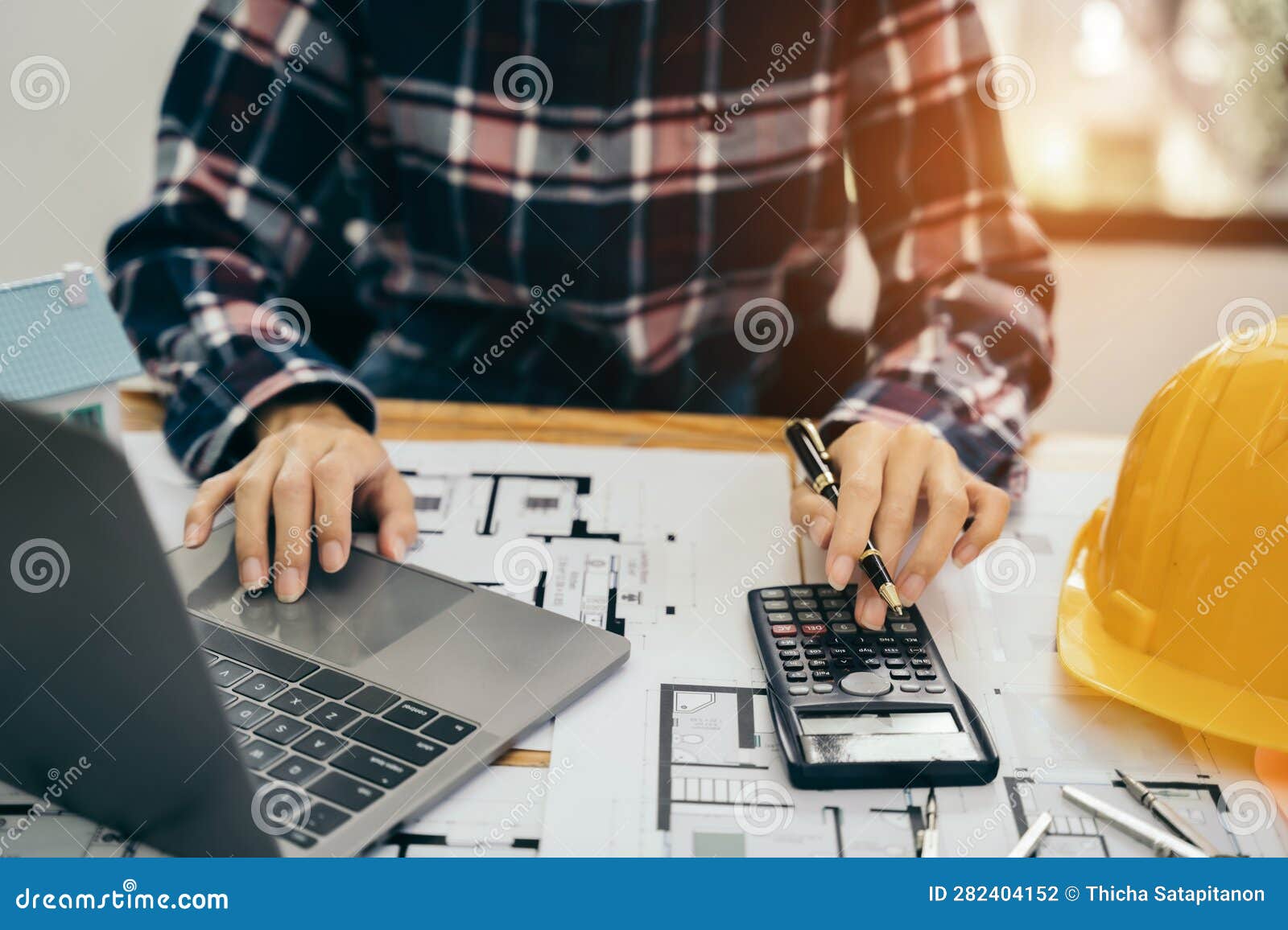civil engineer or architect business useing calculator about calculate the cost with for working building plan  project in