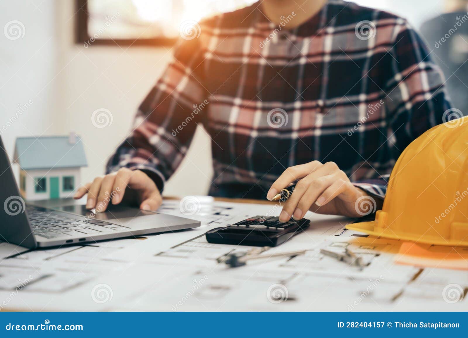 civil engineer or architect business useing calculator about calculate the cost with for working building plan  project in
