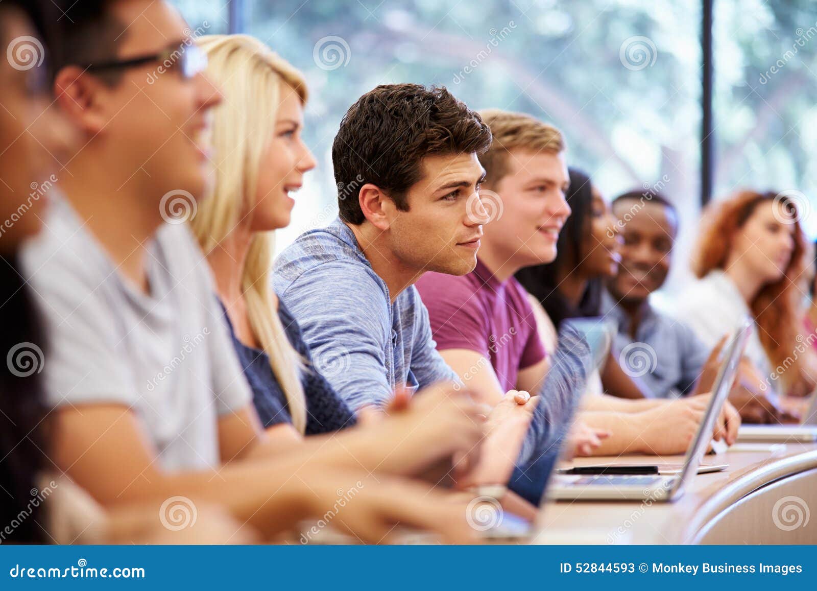 class of university students using laptops in lecture