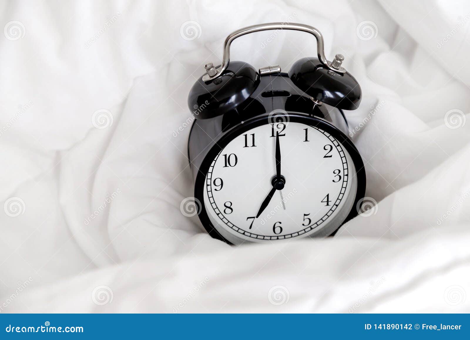 Classic Alarm Clock in Bed, Concept of Morning Routine Stock Photo