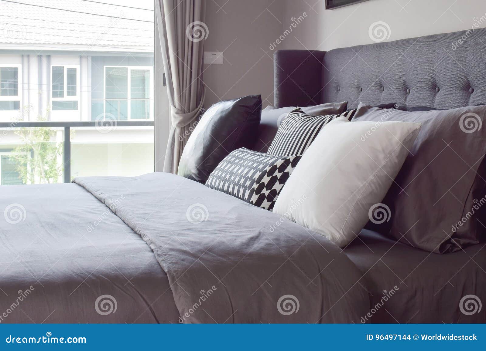 Classic Bedroom Interior with Pillows Next To Window Stock Photo