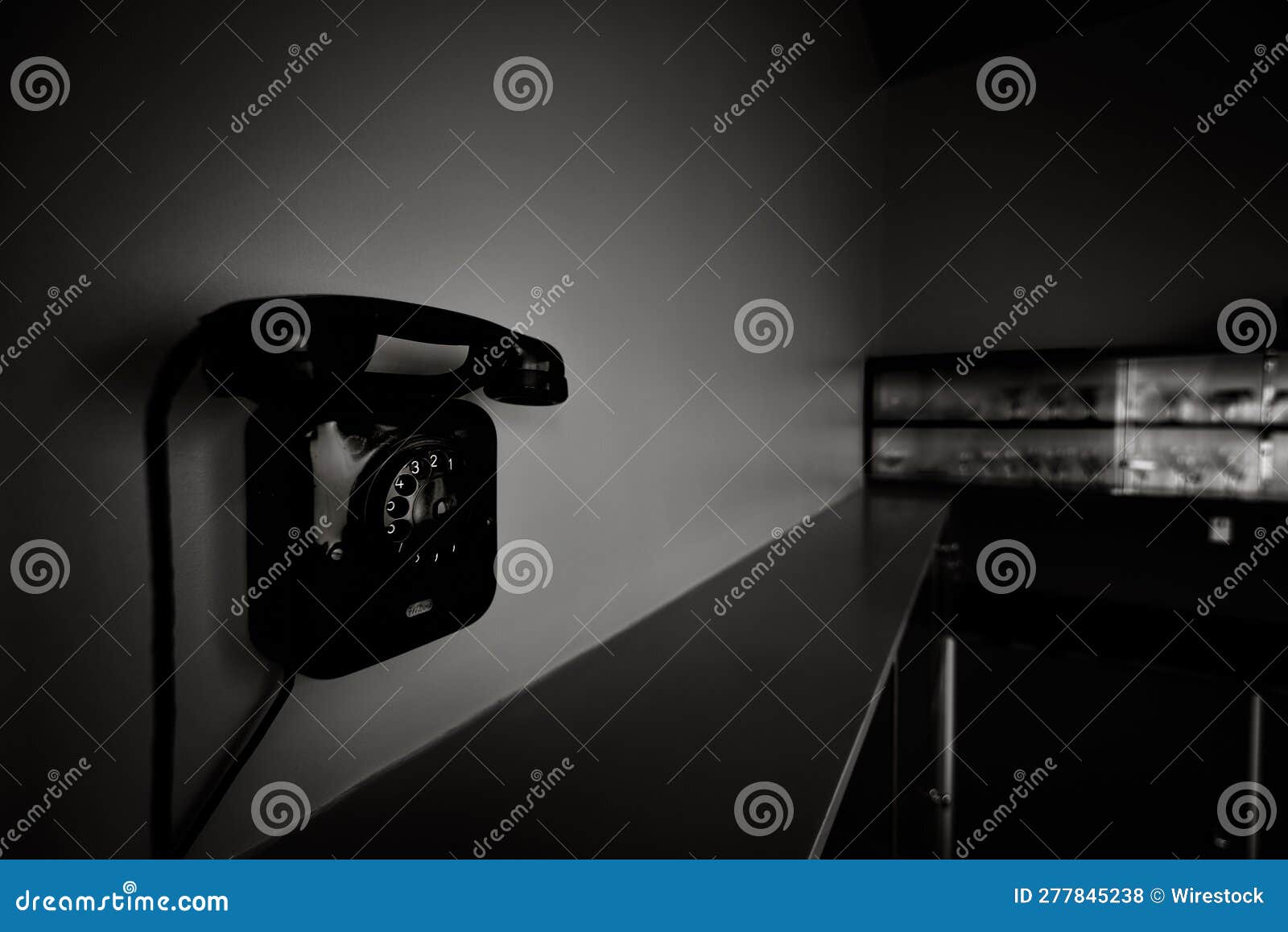 Classic Wallmounted Telephone on the Wall in Grayscale Stock Photo