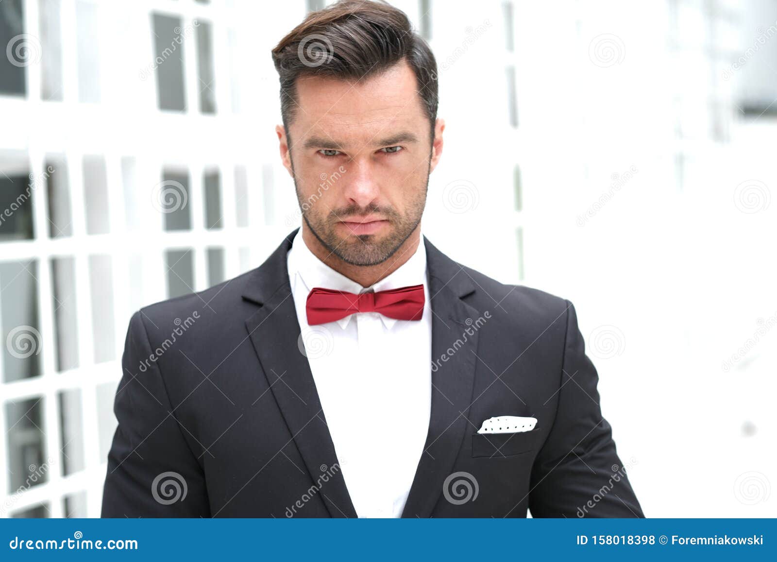 classy look best man wearing black suit red bow tie handsome looks stunning elegant 158018398