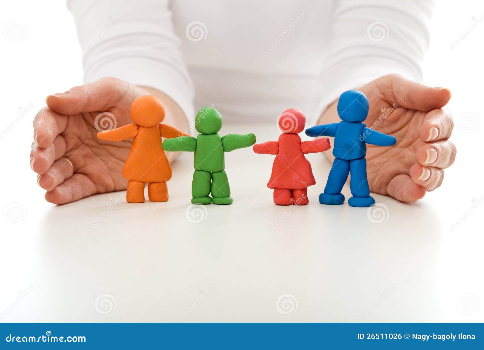 clay people family protected by woman hands