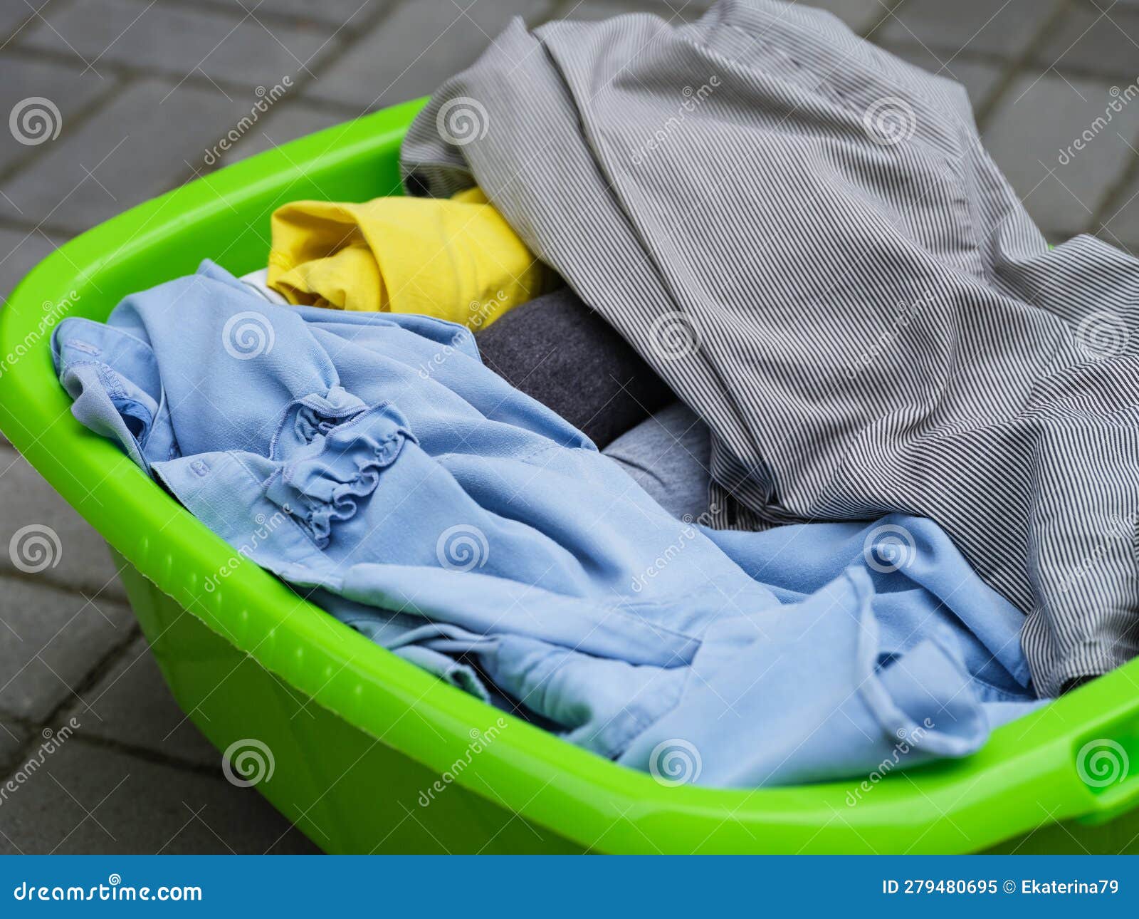 Clean Dried Clothes Laying in a Green Laundry Basket Outdoors Stock ...
