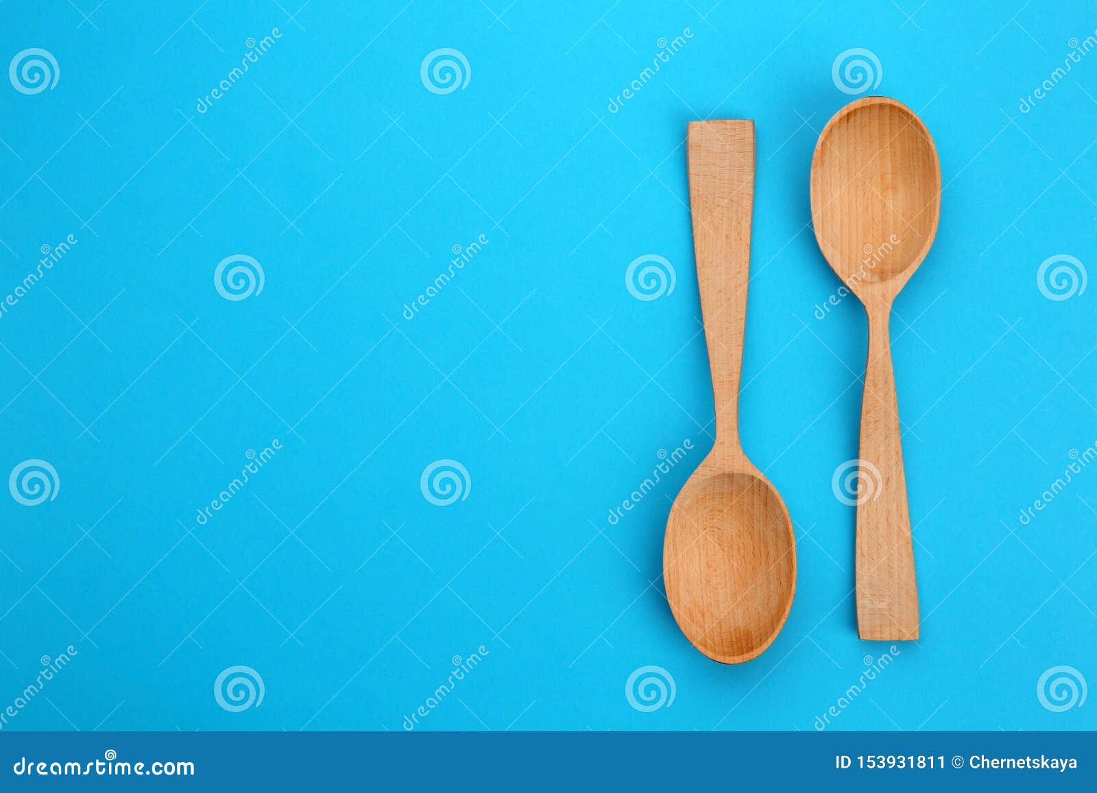 Clean Empty Wooden Spoons on Blue Background, Flat Lay Stock Image