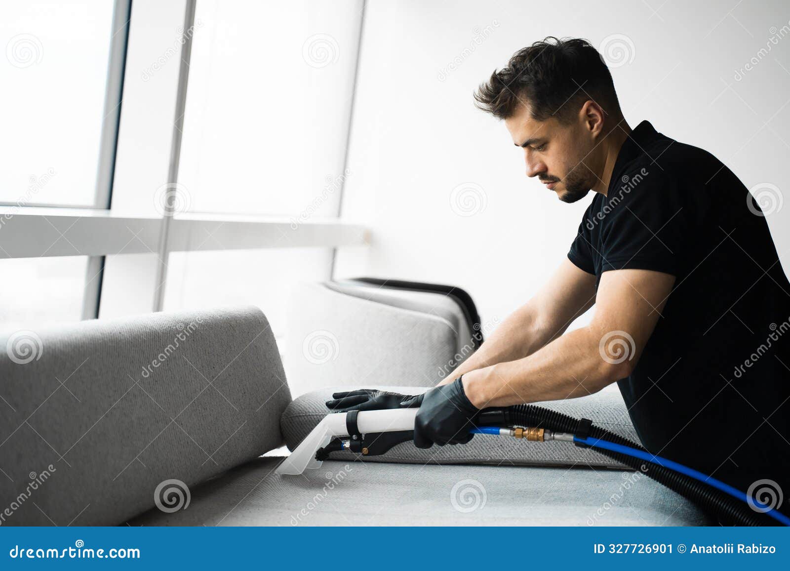 cleaner is dry-cleaning sofa using extractor machine with detergent. using extractor to refresh and clean from dust and