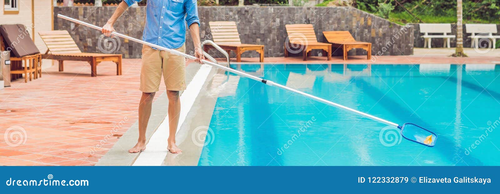 cleaner of the swimming pool . man in a blue shirt with cleaning equipment for swimming pools, sunny banner, long format