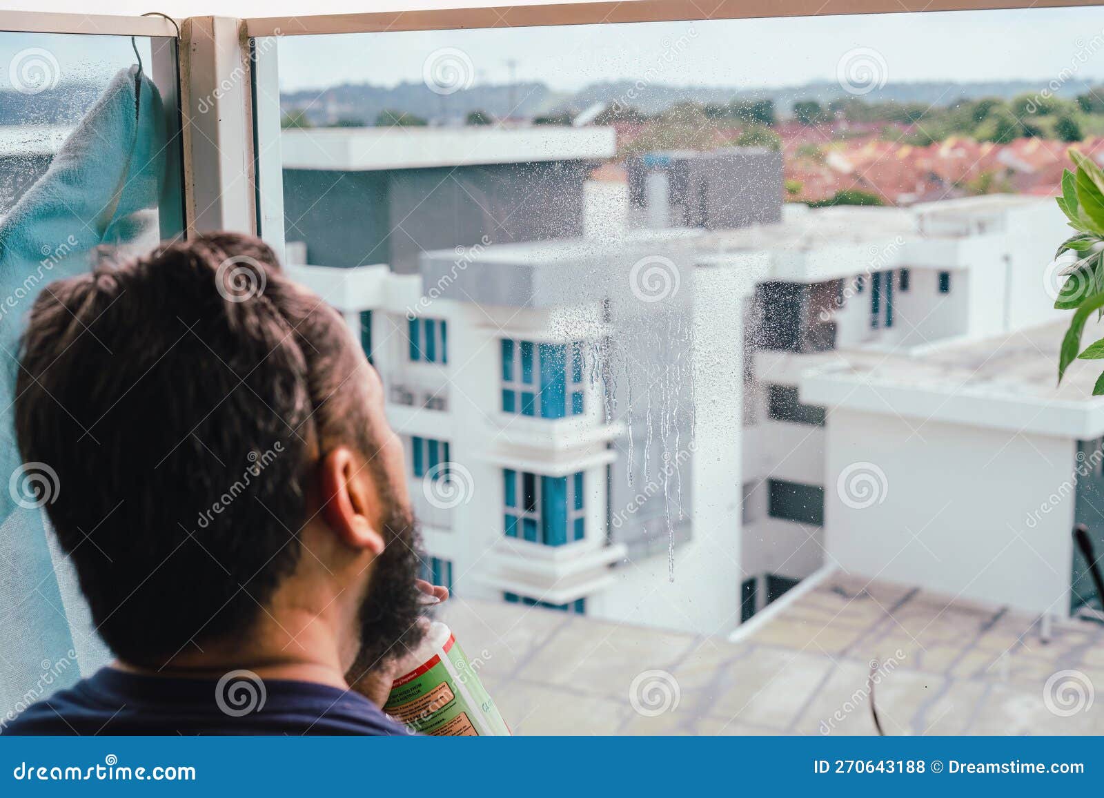 Cleaning the Balcony Glass of an Apartment. Stock Photo Image of