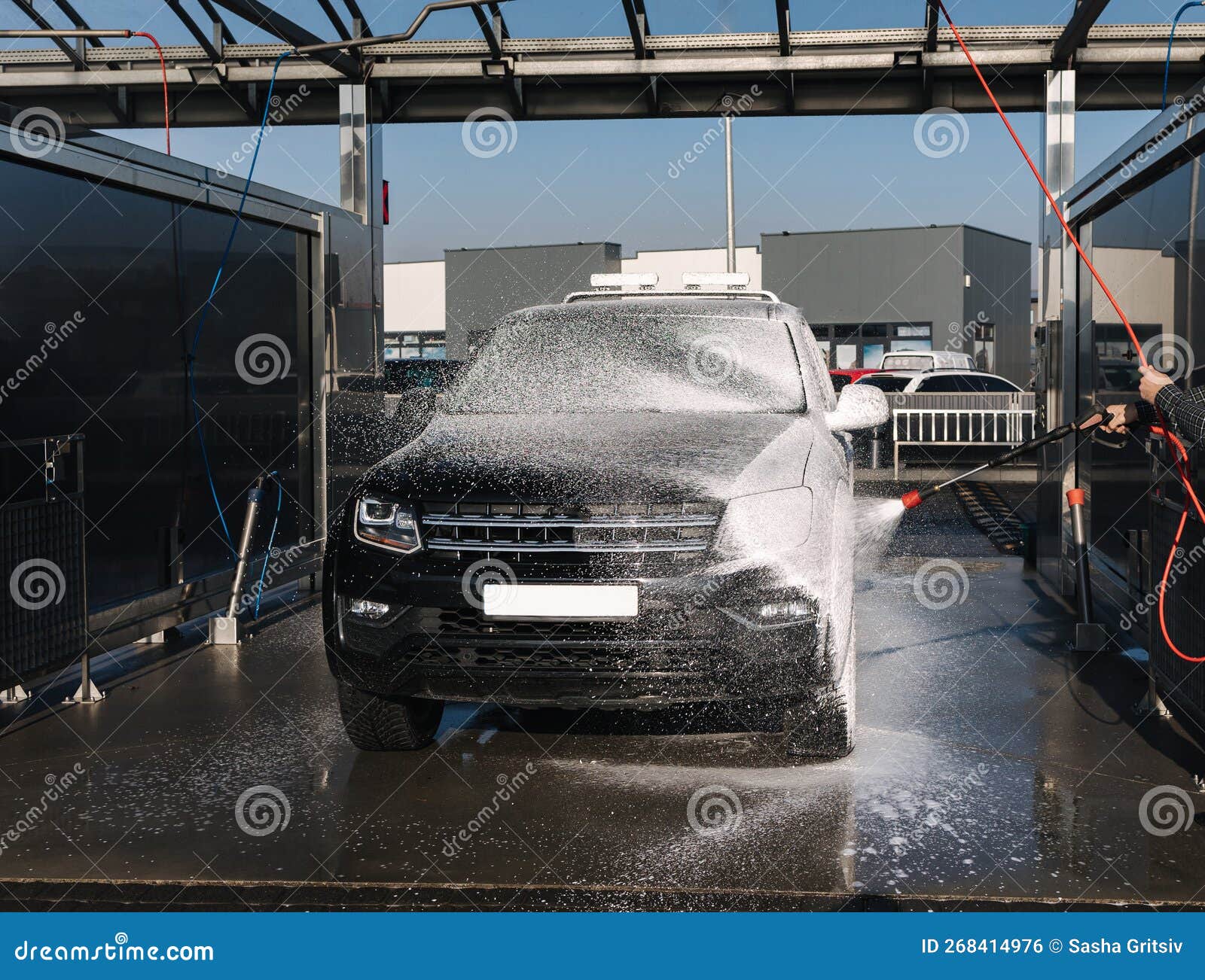 Cleaning Car on Self Service Car Wash. Man Spread Soap Using Jet