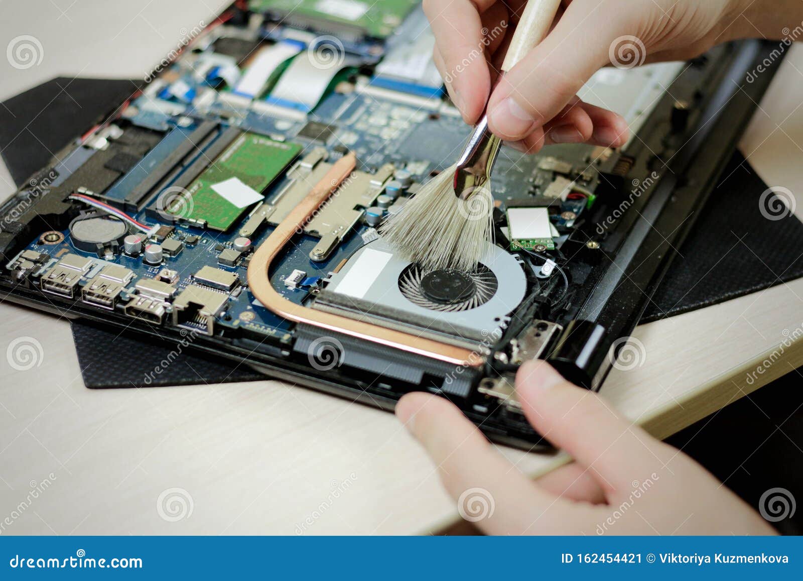 Cleaning the Laptop from Dust with a Brush. Close Up Stock Image