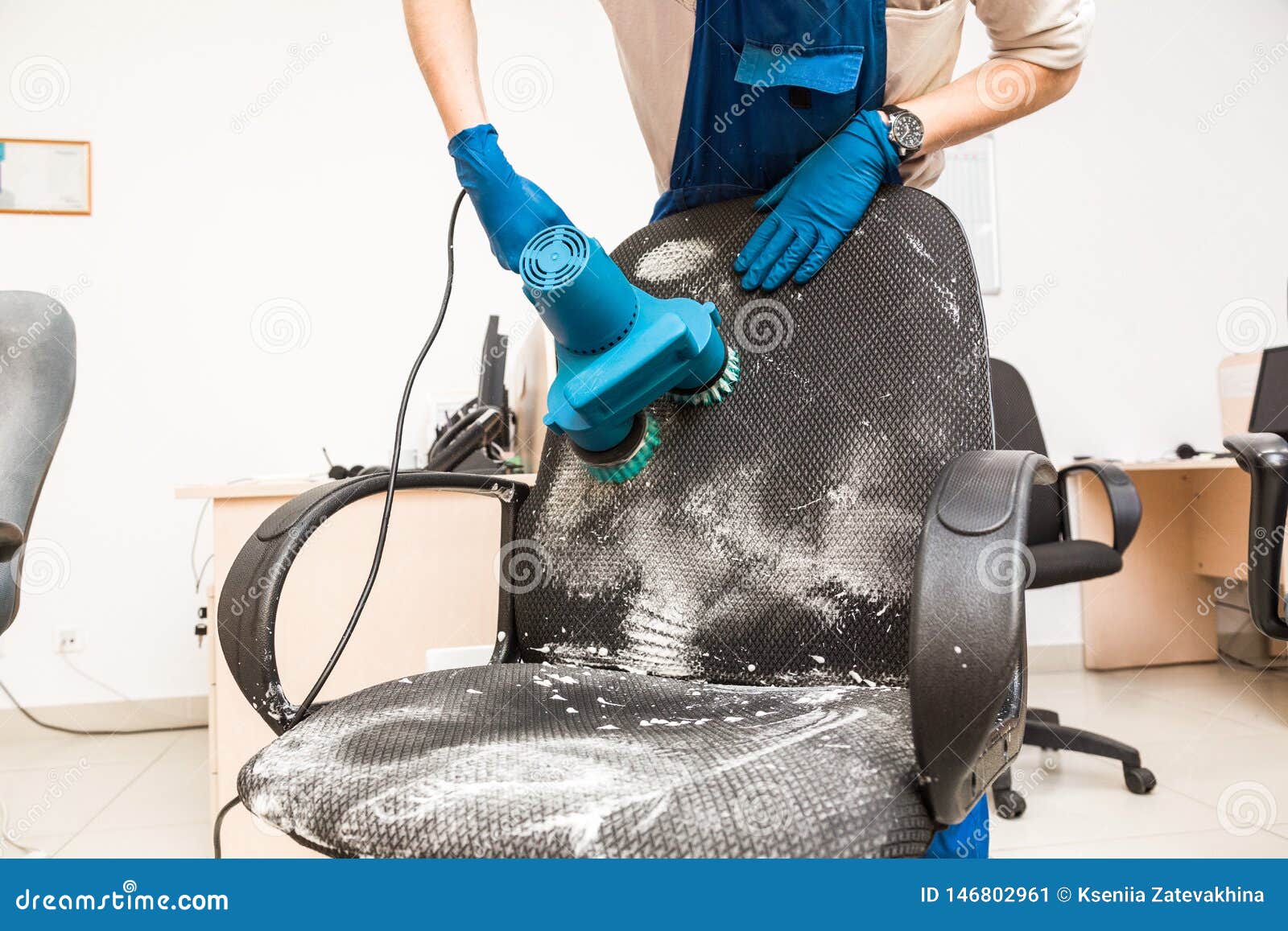 Young Man In Workwear And Rubber Gloves Cleans The Office Chair