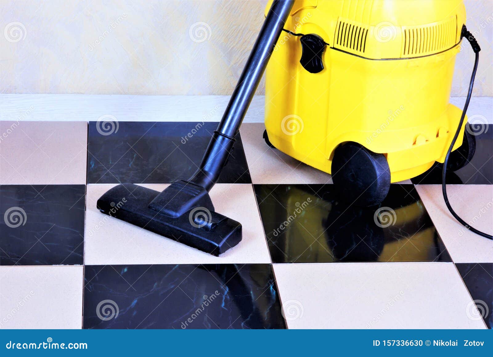 Cleaning Of The Tile Floor Surface With A Vacuum Cleaner