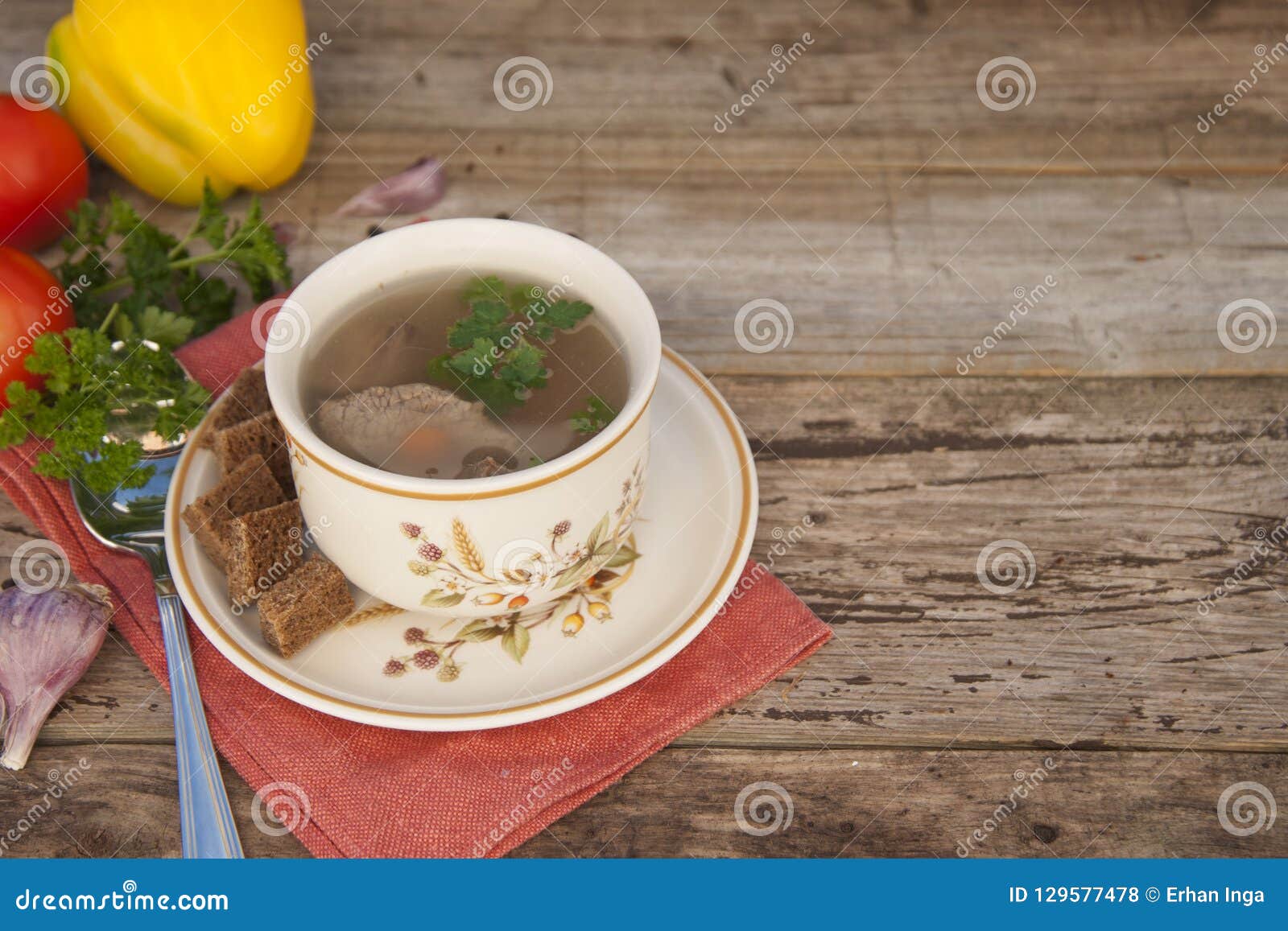 Clear Beef Broth, Bouillon in White Bowl and Vegetables on Wooden Table