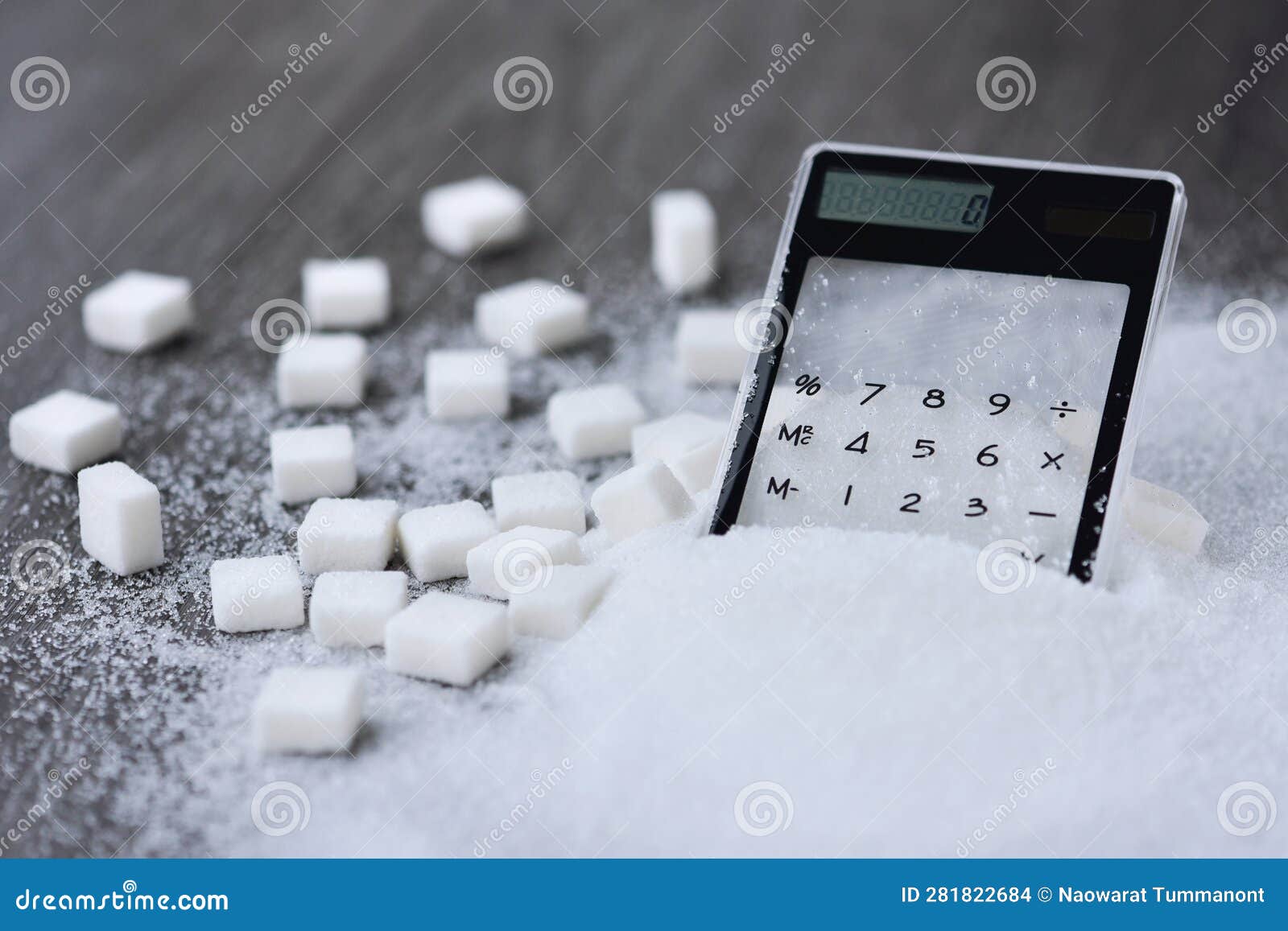 clear calculator on white granulation sugar and cube sugar background.