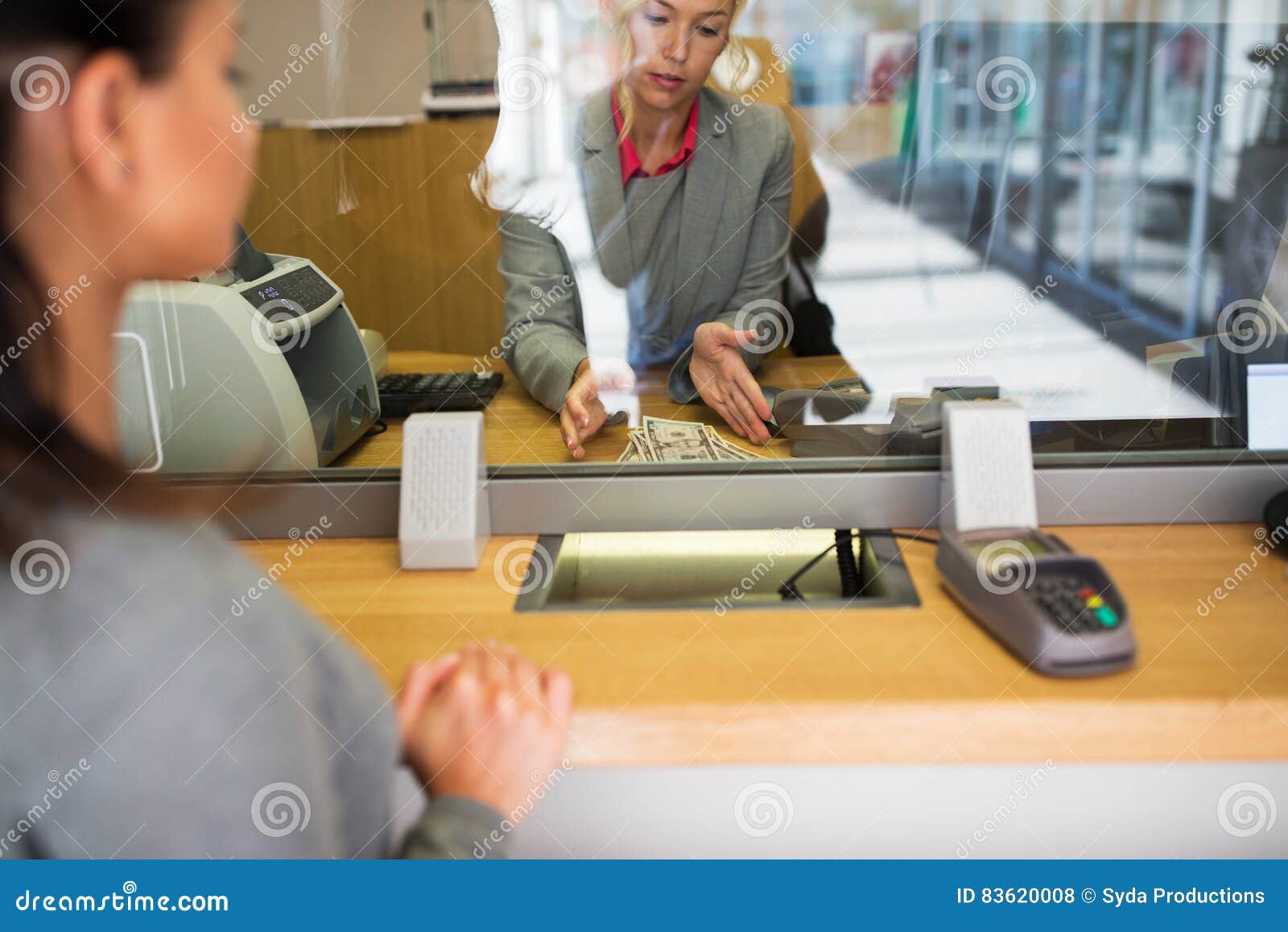 clerk with cash money and customer at bank office