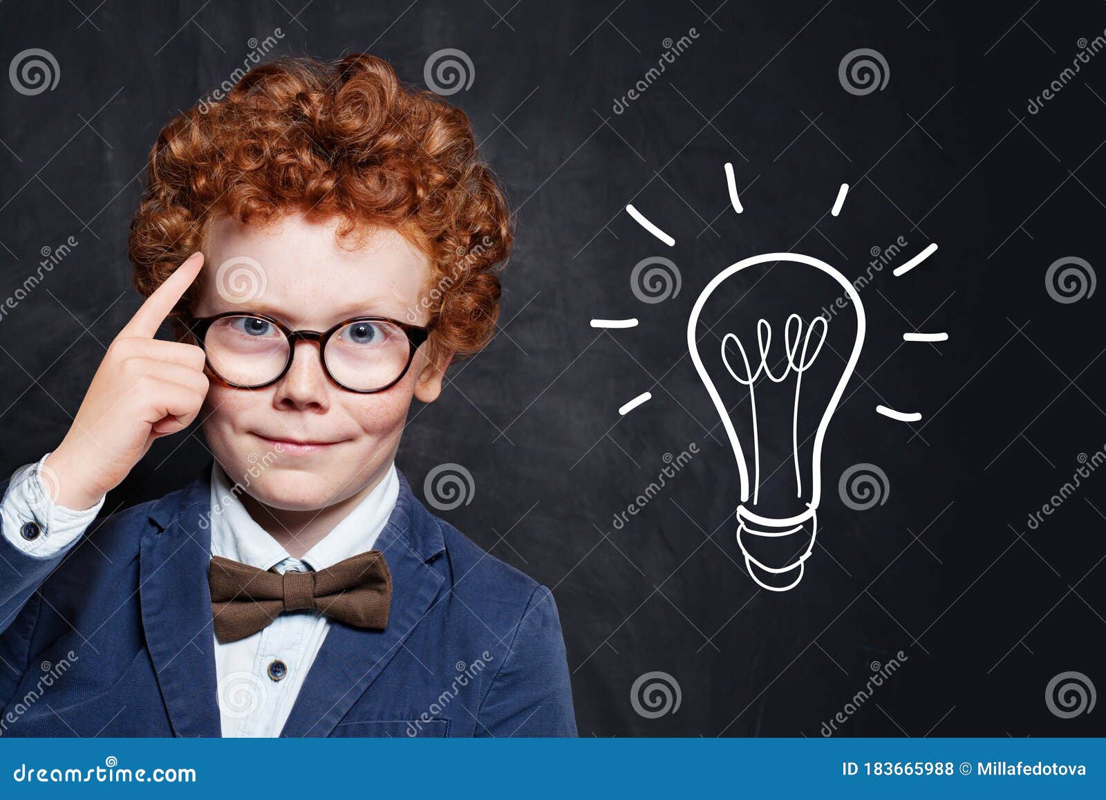 clever boy in glasses with idea lightbulb on blackboard background