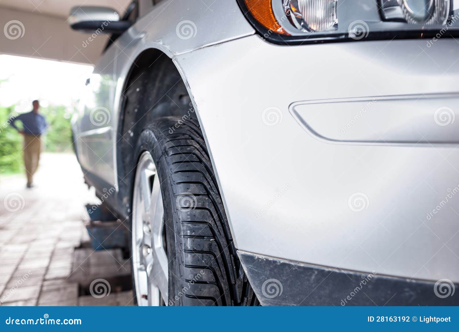 Client Waiting while His Car is Being Inspected in a Garage Stock Photo