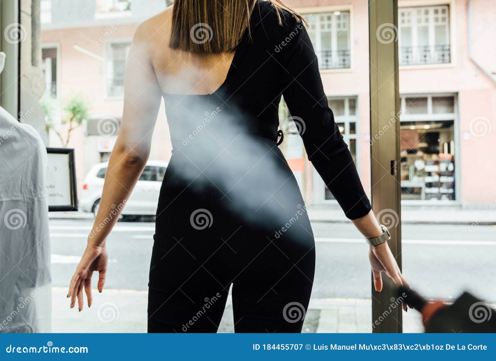 clienta desinfectÃÂ¡ndose con vapor en la puerta de entrada al comercio