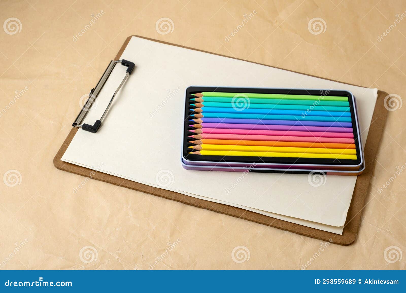 Clipboard with a Blank Sheets of Paper and Colored Pencils on Craft