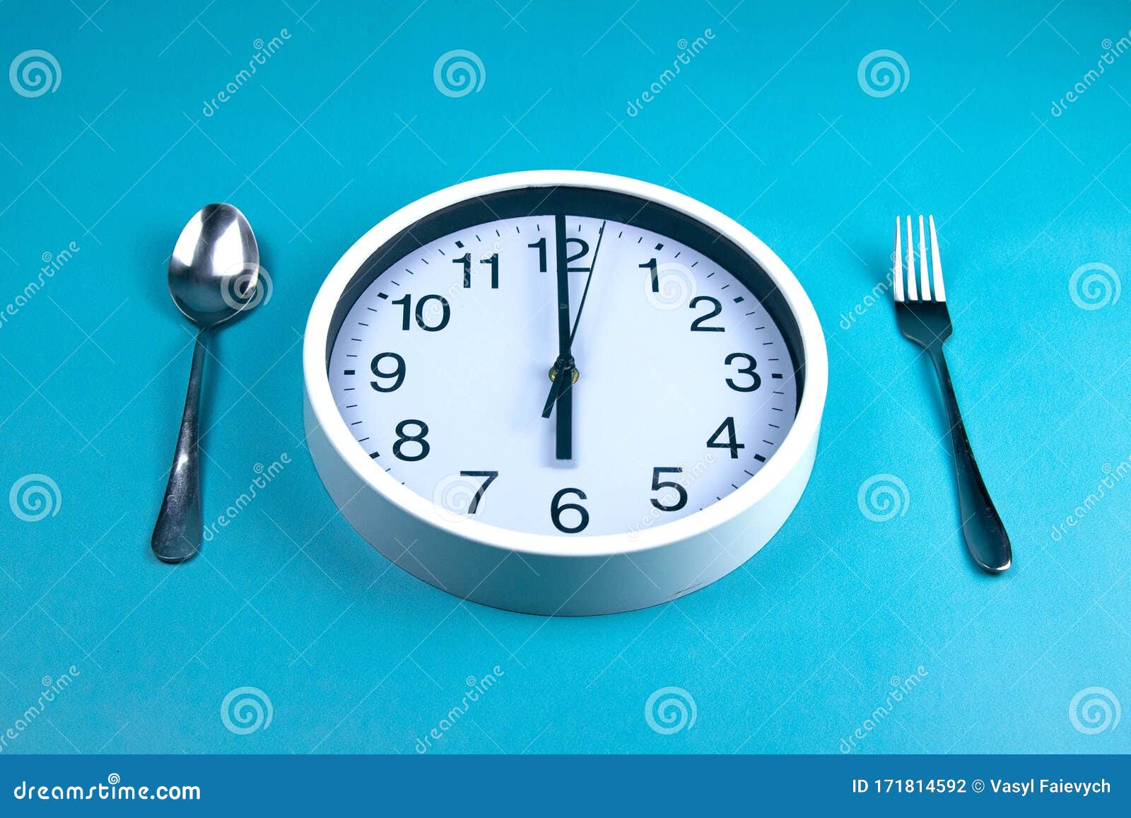 a clock showing exactly 6 hours, next to a fork and a spoon are on a blue background