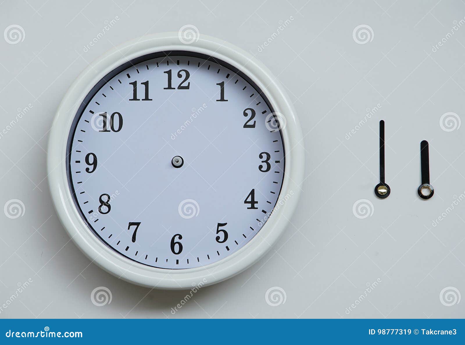 a clockface and an hour hand and the long hand of the wall clock