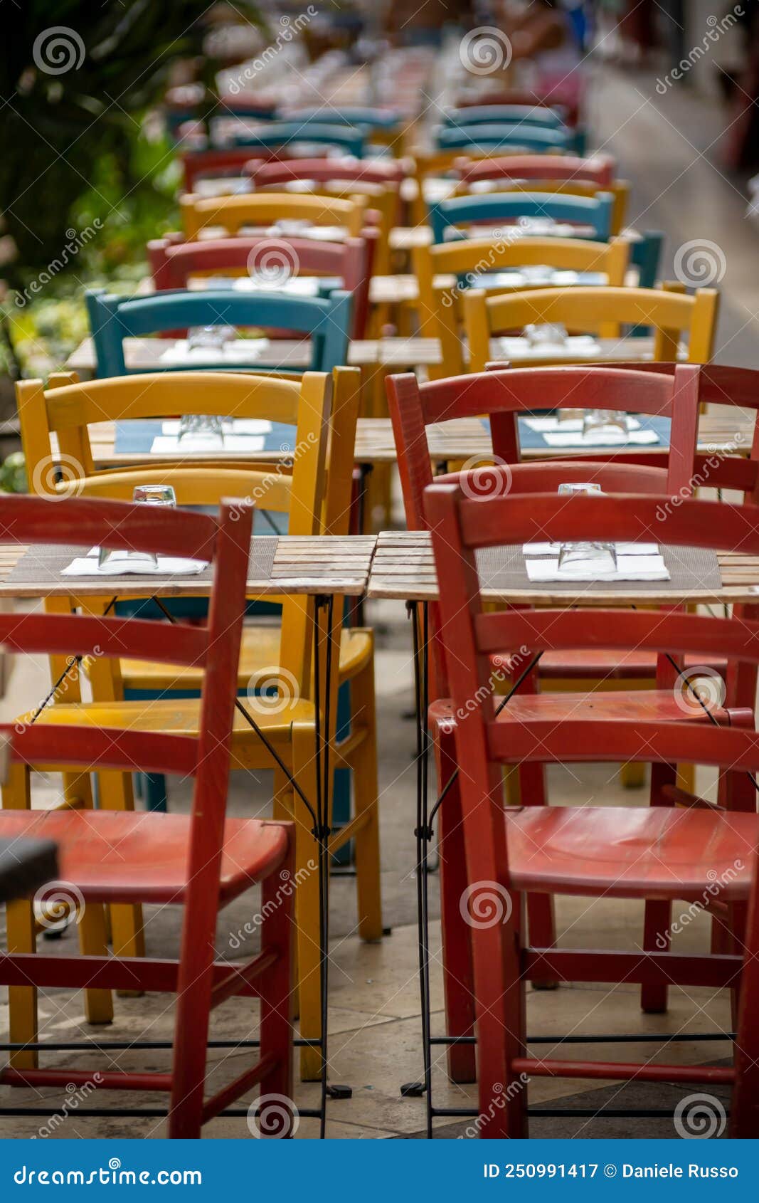 clolored wooden chairs on sidewalk in the city of cagliari, in the region of sardinia, italy, in summer