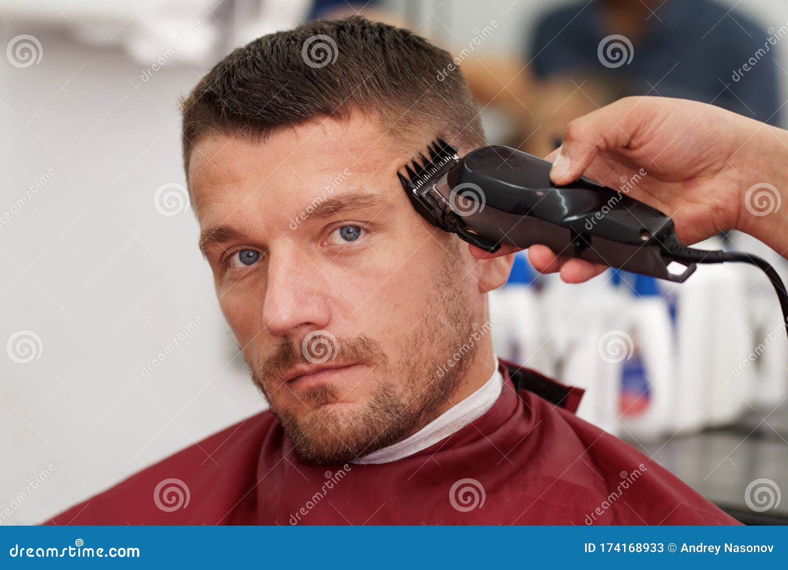 male client getting haircut by hairdresser.